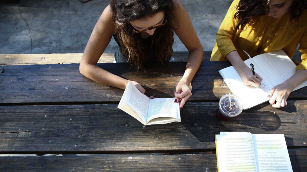A photo showing two young women studying books, taken from above. Credit Alexis Brown.