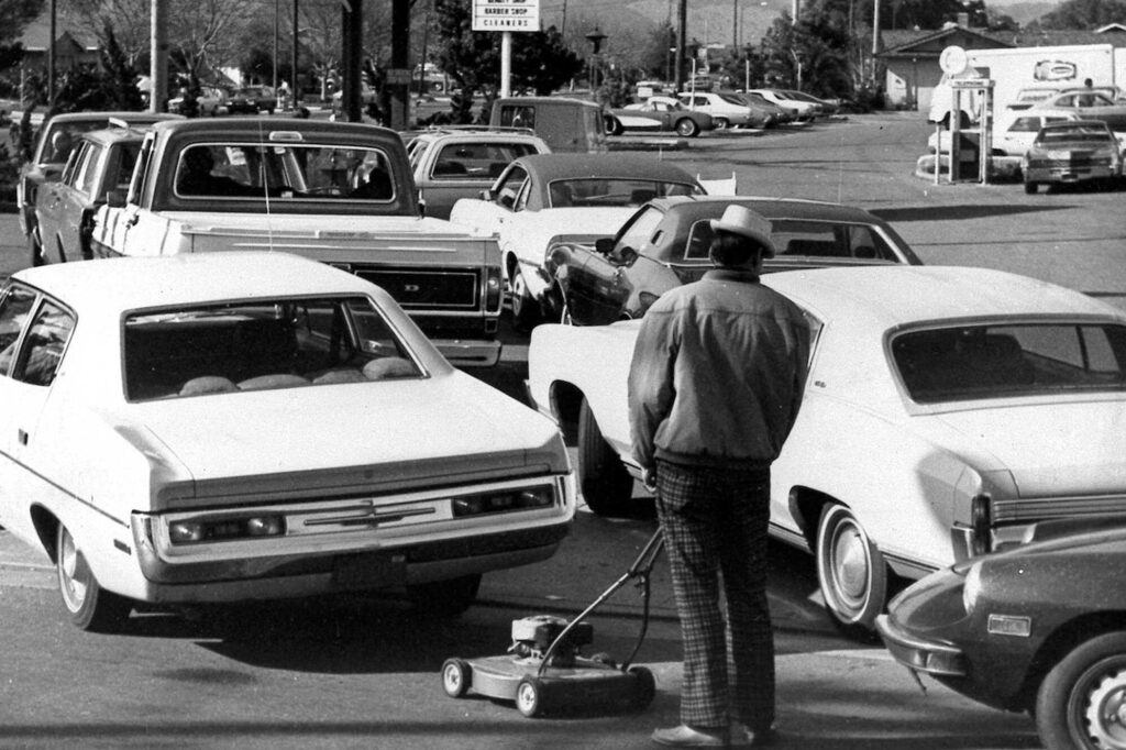 Drivers and a man pushing a lawnmower line up at gas station in San Jose, Calif., on March 15, 1974. AP.