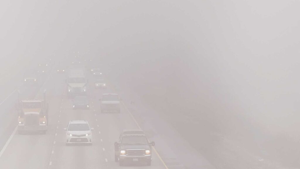 Photo of a highway with vehicles barely visible through heavy smog. Credit Ivan Bogdanov, Unsplash.